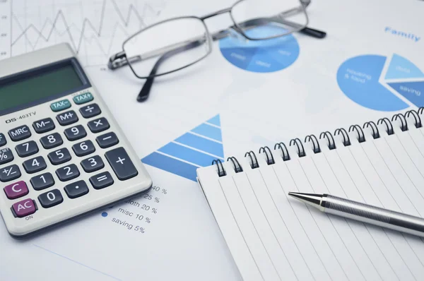 Pen book glasses and calculator on financial chart and graph — Stock Photo, Image