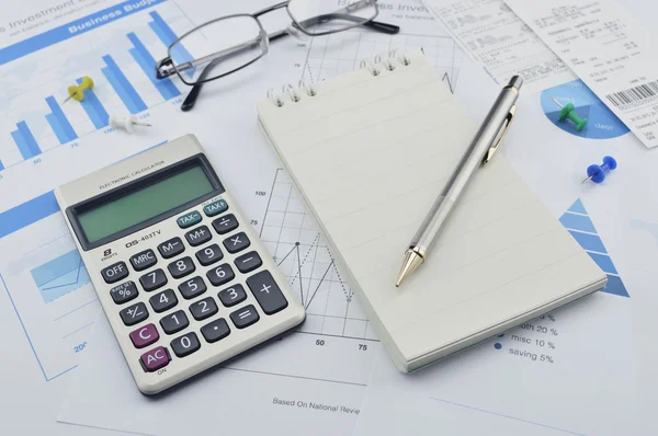 Pen, calculator and notebook on financial chart and graph, accou — Stock Photo, Image