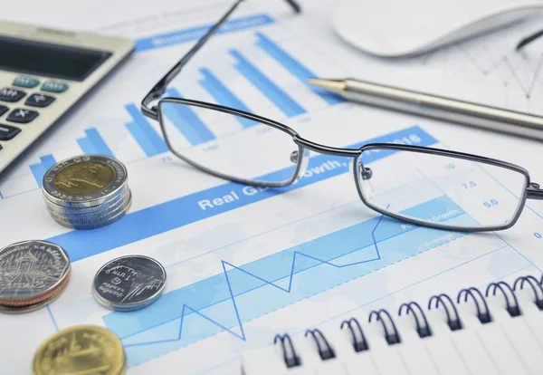 Glasses, coin and pen on financial chart and graph, investment c — Stock Photo, Image