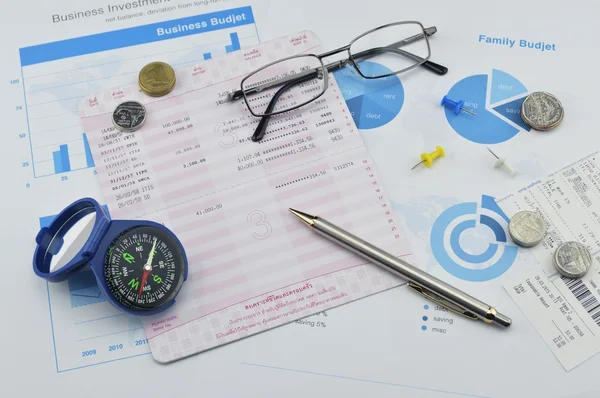 Compass, pen, glasses and coin on saving book, accounting backgr — Stock Photo, Image