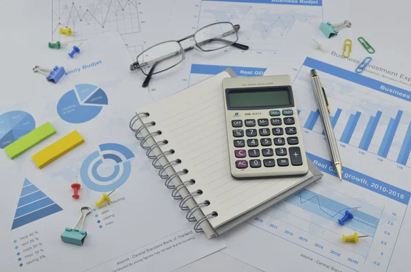 Calculator, notebook, pen, pin and glasses on financial graph, a — Stock Photo, Image