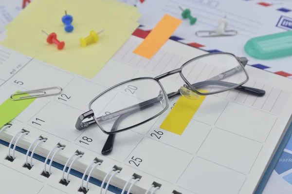 Szemüveg, post It jegyzetek és pin üzleti diary-oldal — Stock Fotó