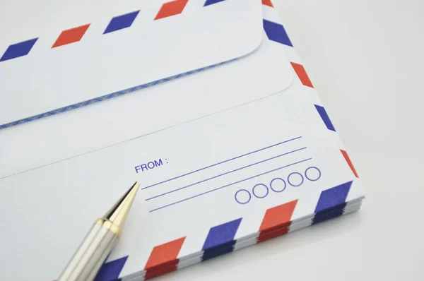 Stack of air mail envelopes with pen on white background — Stock Photo, Image