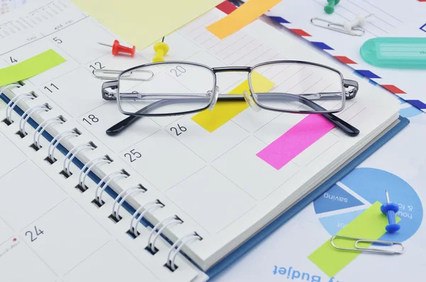 Gafas con mensaje Notas y pin en la página del diario de negocios —  Fotos de Stock