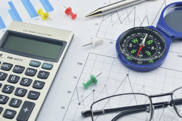 Blue compass, calculator, pen and glasses on graph paper, succes — Stock Photo, Image