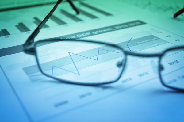 Glasses on financial chart and graph, accounting background — Stock Photo, Image