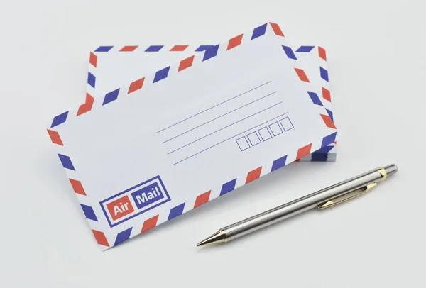 Stack of air mail envelopes and pen on white — Stock Photo, Image