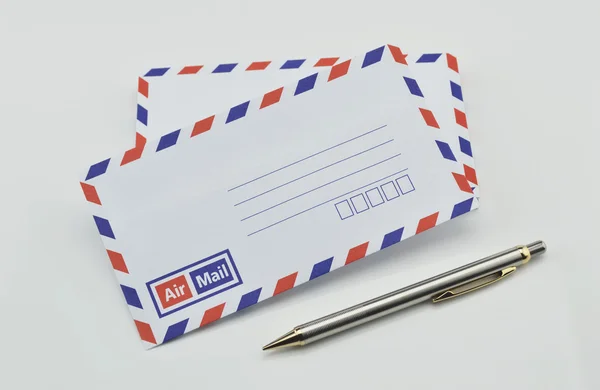 Stack of air mail envelopes and pen on white — Stock Photo, Image
