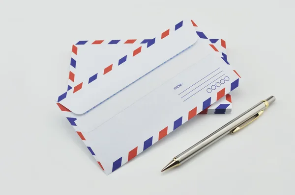 Stack of air mail envelopes and pen on white — Stock Photo, Image