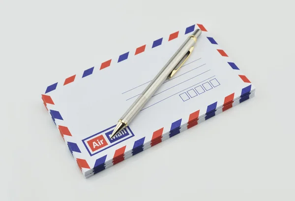 Stack of air mail envelopes and pen on white — Stock Photo, Image