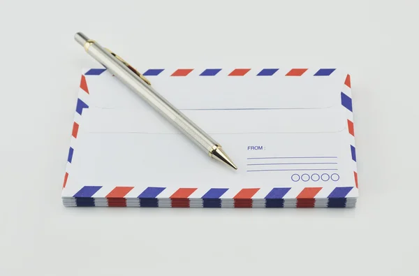 Пачка конвертов авиапочты и ручка на белом фоне — стоковое фото