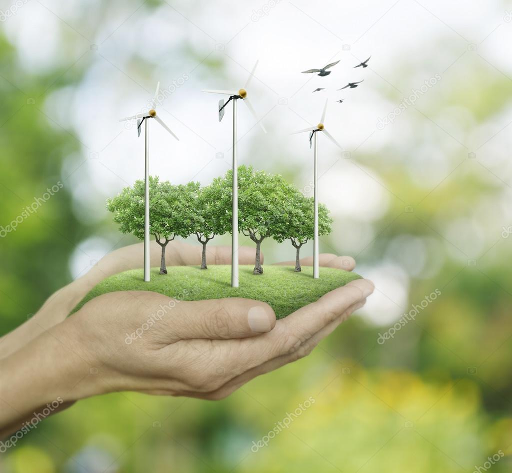 Wind turbines and trees on hands over green bokeh background, Ec