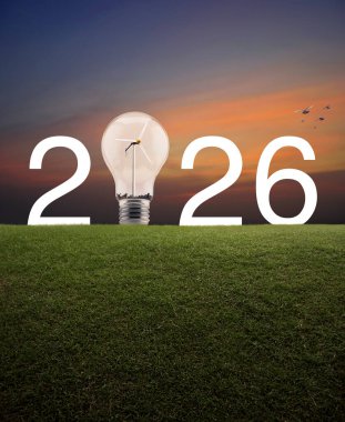 2026 beyaz yazı ve ampul içinde rüzgar türbini olan yeşil çimlerin üzerinde günbatımı gökyüzünde kuşlarla birlikte, mutlu yıllar 2026 yeşil ekoloji ve tasarruf enerji kavramı.