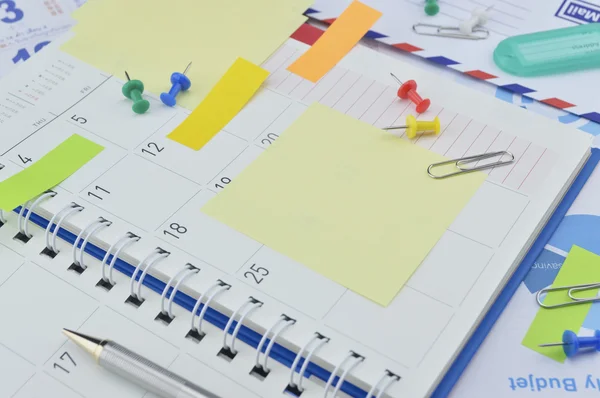 Clipe com notas adesivas coloridas, caneta e alfinete no diário de negócios — Fotografia de Stock