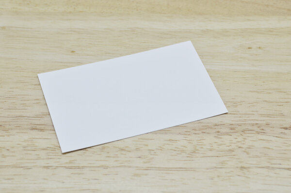 Blank business card on wooden table