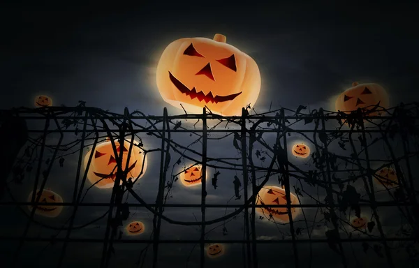 Halloween pumpkin and fence with dry leaves over dark sky, Hallo — Stock Photo, Image