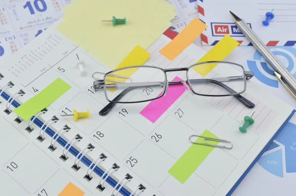 Gafas con notas adhesivas de colores y pluma en la página del diario —  Fotos de Stock