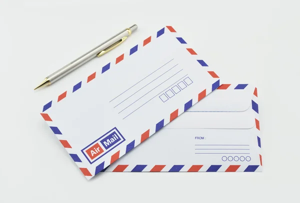 Stack of air mail envelopes and pen on white — Stock Photo, Image