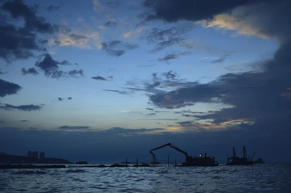 Силуэты строительного крана на закате в море, Паттайя — стоковое фото