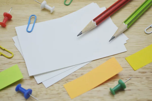 Именная карточка, карандаш, клип и липкие заметки на столе — стоковое фото