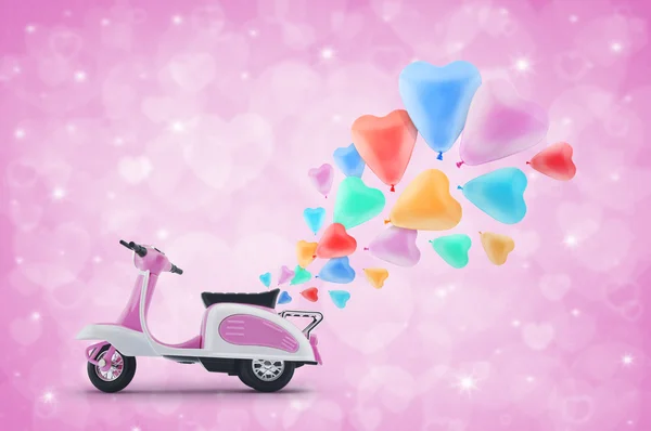 Rosa scooter juguete con colorido corazón amor globo en rosa claro — Foto de Stock