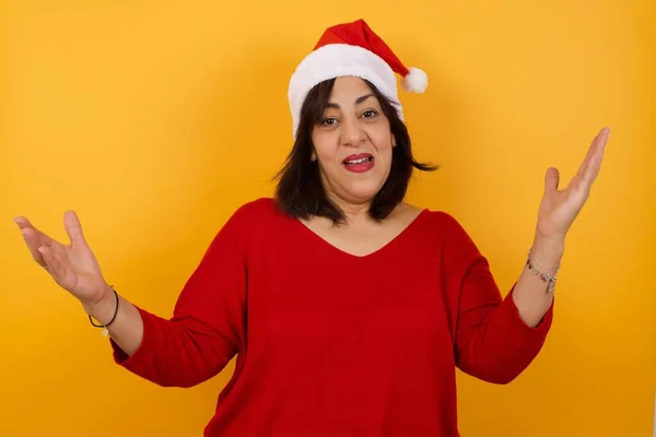Fröhliche Arabische Frau Mittleren Alters Mit Weihnachtsmütze Macht Eine Willkommensgeste — Stockfoto