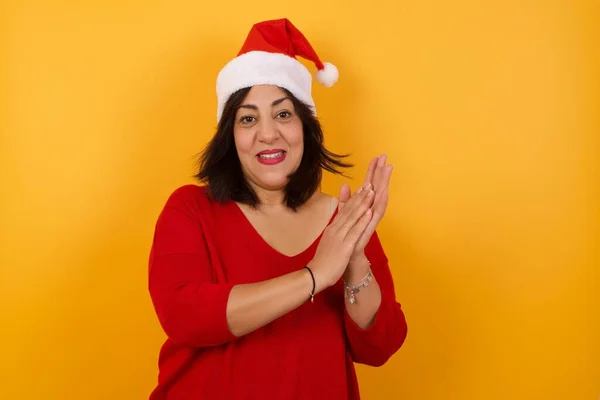 Arabische Frau Mittleren Alters Mit Weihnachtsmütze Steht Vor Gelber Wand — Stockfoto