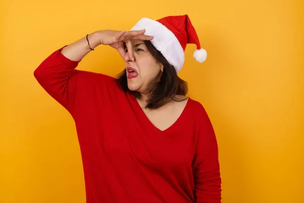 Displeased Arab Middle Aged Woman Wearing Christmas Hat Plugs Nose — Stock Photo, Image