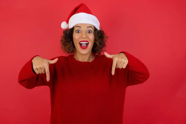 Stüdyo Portresi Kıvırcık Saçlı Noel Şapkası Takan Kırmızı Arka Planda — Stok fotoğraf