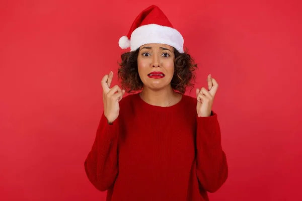 Mulher Bonita Usando Chapéu Natal Suéter Vermelho Segurando Dedos Cruzados — Fotografia de Stock