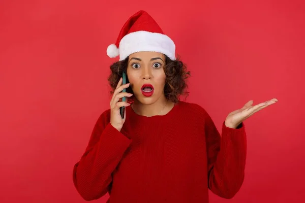 Noel Şapkası Kırmızı Süveter Giyen Genç Bir Kadın Telefonda Kırmızı — Stok fotoğraf