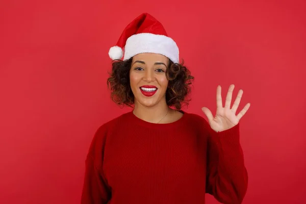 Junge Frau Mit Weihnachtsmütze Und Rotem Pullover Steht Vor Roter — Stockfoto