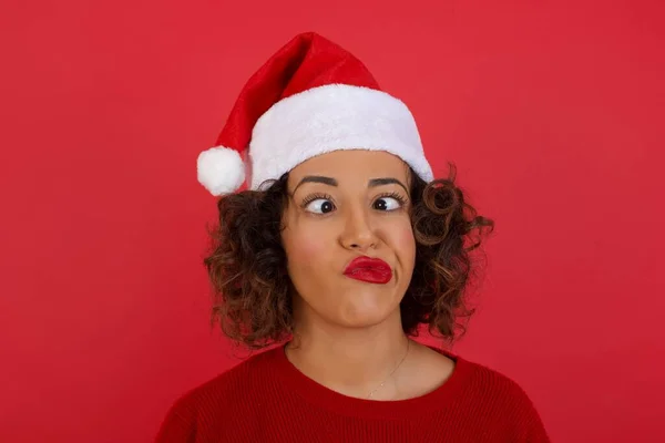 Noel Şapkası Takan Kırmızı Kazak Giyen Komik Bir Kadın Gözlerini — Stok fotoğraf