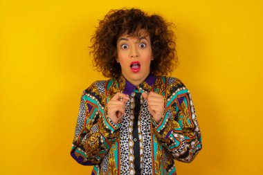 İnsan yüzü ifadeleri ve duyguları. Renkli gömlek giyen genç bir Arap kadının portresi paniğe kapılmış görünüyor, ellerini yüzüne yakın tutuyor, ağzı sonuna kadar açık. Umutsuzluk ve şok içindeki bir kadın