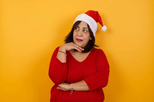 Nachdenkliche Arabische Frau Mittleren Alters Mit Weihnachtsmütze Die Hand Unter — Stockfoto