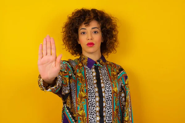 Young beautiful Caucasian woman doing stop gesture with palm of the hand. Warning expression with negative and serious gesture on the face isolated over background.