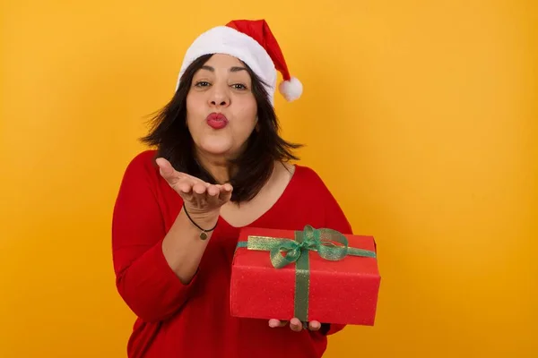 Nette Attraktive Arabische Frau Mittleren Alters Mit Weihnachtsmütze Und Geschenkpusten — Stockfoto