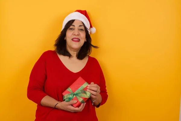 Schüchterne Arabische Frau Mittleren Alters Mit Weihnachtsmütze Und Geschenk Lächelt — Stockfoto