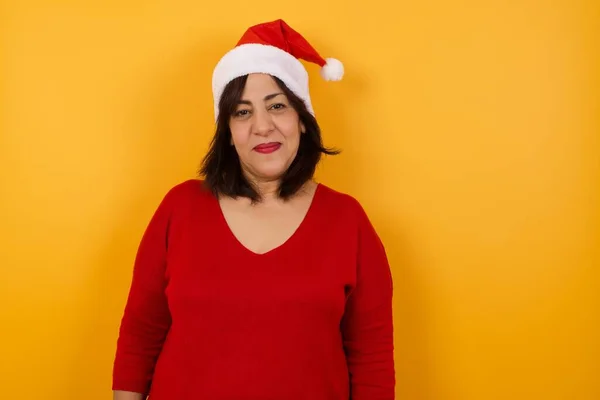 カメラを見ているクリスマスの帽子をかぶったアラブ中年の女性のスタジオショットを閉じる — ストック写真