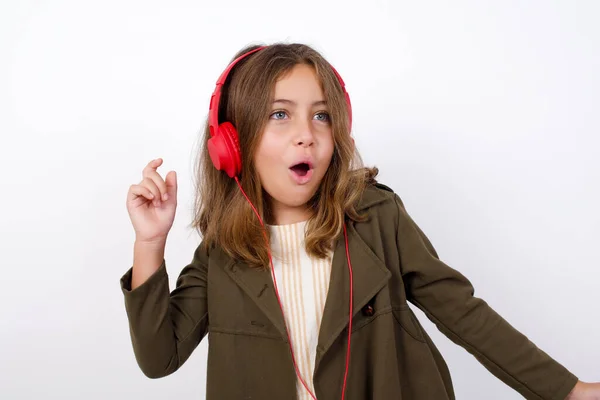 Gadis Kecil Yang Cantik Mengenakan Mantel Hijau Dengan Headphone Latar — Stok Foto