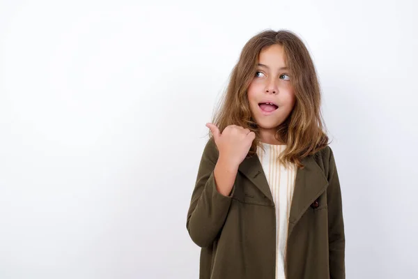 Hermosa Niña Vistiendo Abrigo Verde Apuntando Hacia Atrás Sobre Fondo — Foto de Stock