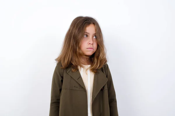 漂亮的小女孩穿着绿色外套 望着外面的白色背景 — 图库照片