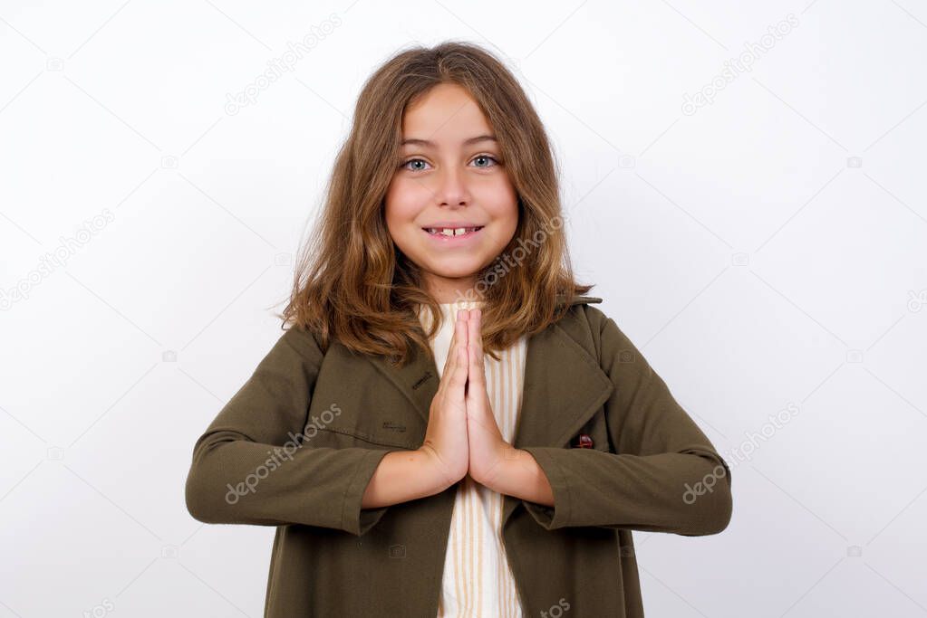 beautiful  little girl wearing green coat posing on white  background  