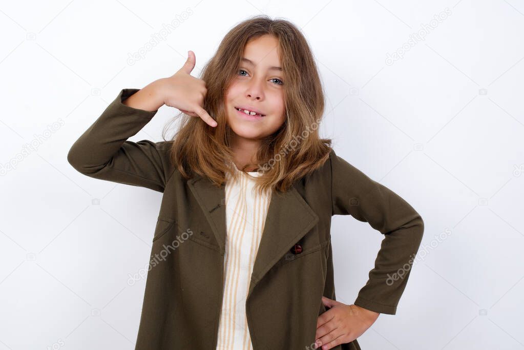 Young beautiful Caucasian little girl with call me gesture on white  background  