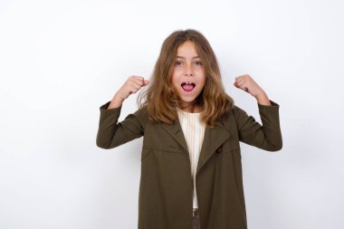 Güçlü, başarılı, kararlı, beyaz arka planda tişört giyen kollarını sıkan, sevinç ve heyecanla bağıran genç kızın portresini kaldır. Zafer, başarı ve başarı kavramı.