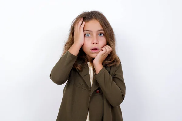 Jonge Sombere Kleine Meid Staat Tegen Een Witte Achtergrond Verbergt — Stockfoto