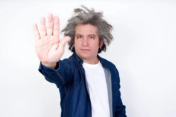 手のひらで停止ジェスチャーをする白いスタジオの背景に立っているアフロ灰色の髪のハンサムな男 — ストック写真