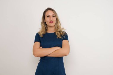 Kollarını kavuşturmuş güzel beyaz bir kadın. Gri arka planda duruyor. Reklam kavramı.