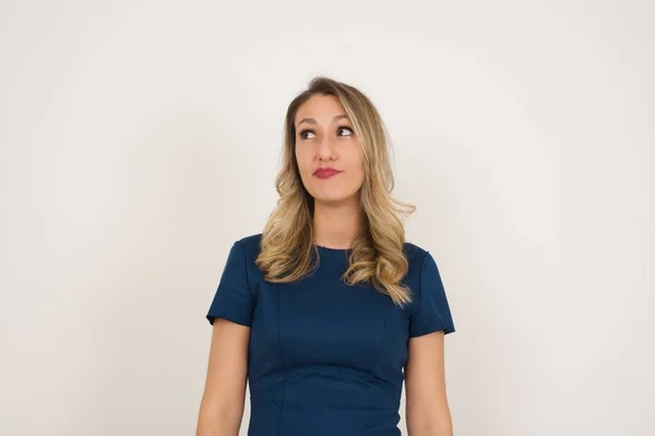 美丽的加拿大金发女人穿着蓝色衣服抬头看 站在白色的背景 广告概念 — 图库照片