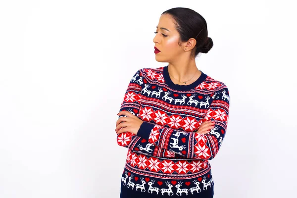 성탄절 스웨터를 교차하는 화난젊고 아름다운 여성의 소식을 표정으로 바라봄 — 스톡 사진